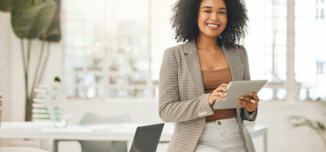 happy-businesswoman-using-a-digital-tablet-young-leading-businesswoman-using-a-wireless-tablet-creative-designer-working-in-her-agency-designer-standing-in-her-office-using-an-online-app