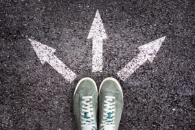 shoes-and-arrows-pointing-in-different-directions-on-asphalt-floor